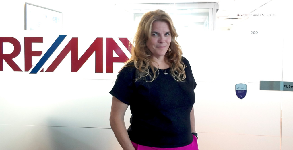 Jacquie stands confidently outside of her brokerage -- Jacquie se tient en toute confiance en dehors de son courtage